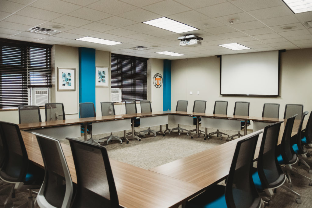 Conference room set up for a meeting with projector and screen