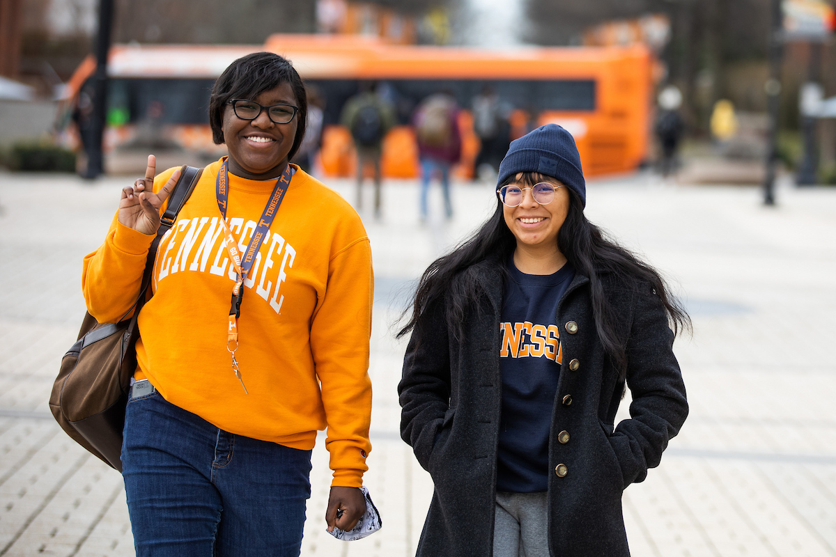 Students smile at the camera while walking down Ped walkway on the first day of spring classes on January 24, 2022.